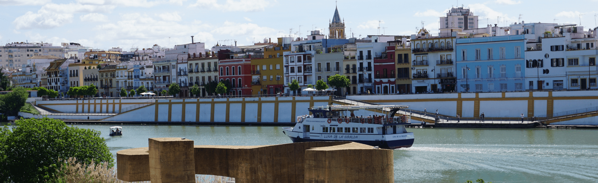 Wide shot of the city showing ferry boats on the river