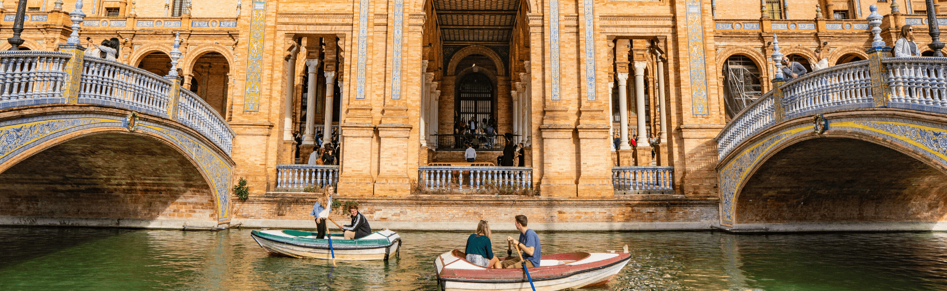row boats sailing along canals and under bridges