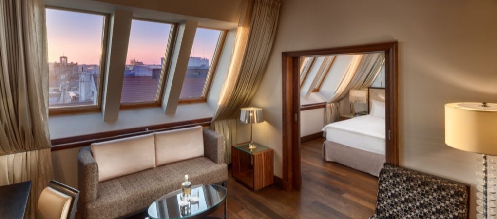 hotel room lounge area where you can observe the sun setting over the city