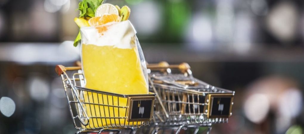 artistic cocktails with a lemon drink sitting in a small shopping trolley