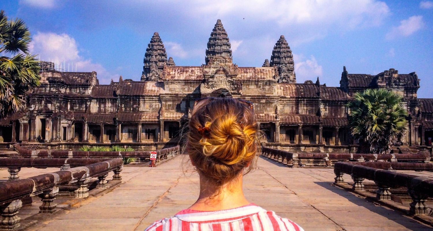 person standing on flat bridge in front of an ancient city
