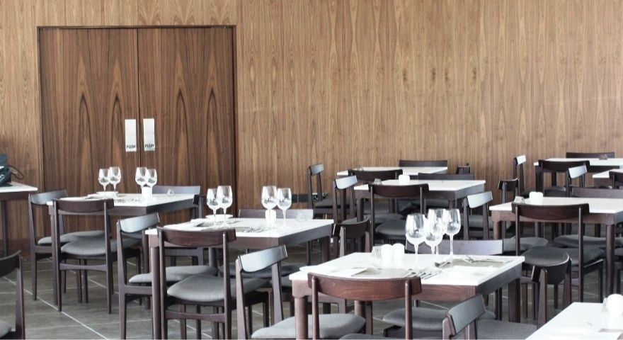 indoor dining room with wine glasses on each table
