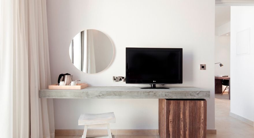 flat-screen tv sitting on a desk in the hotel room