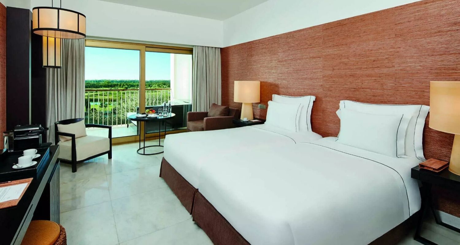 Spacious hotel room with a large bed and balcony terrace