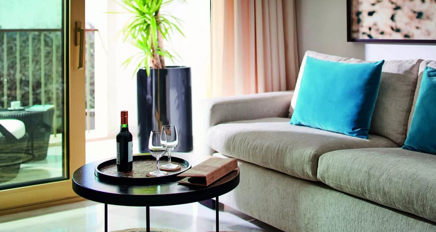 Hotel room lounge area with a sofa and bottle of red wine