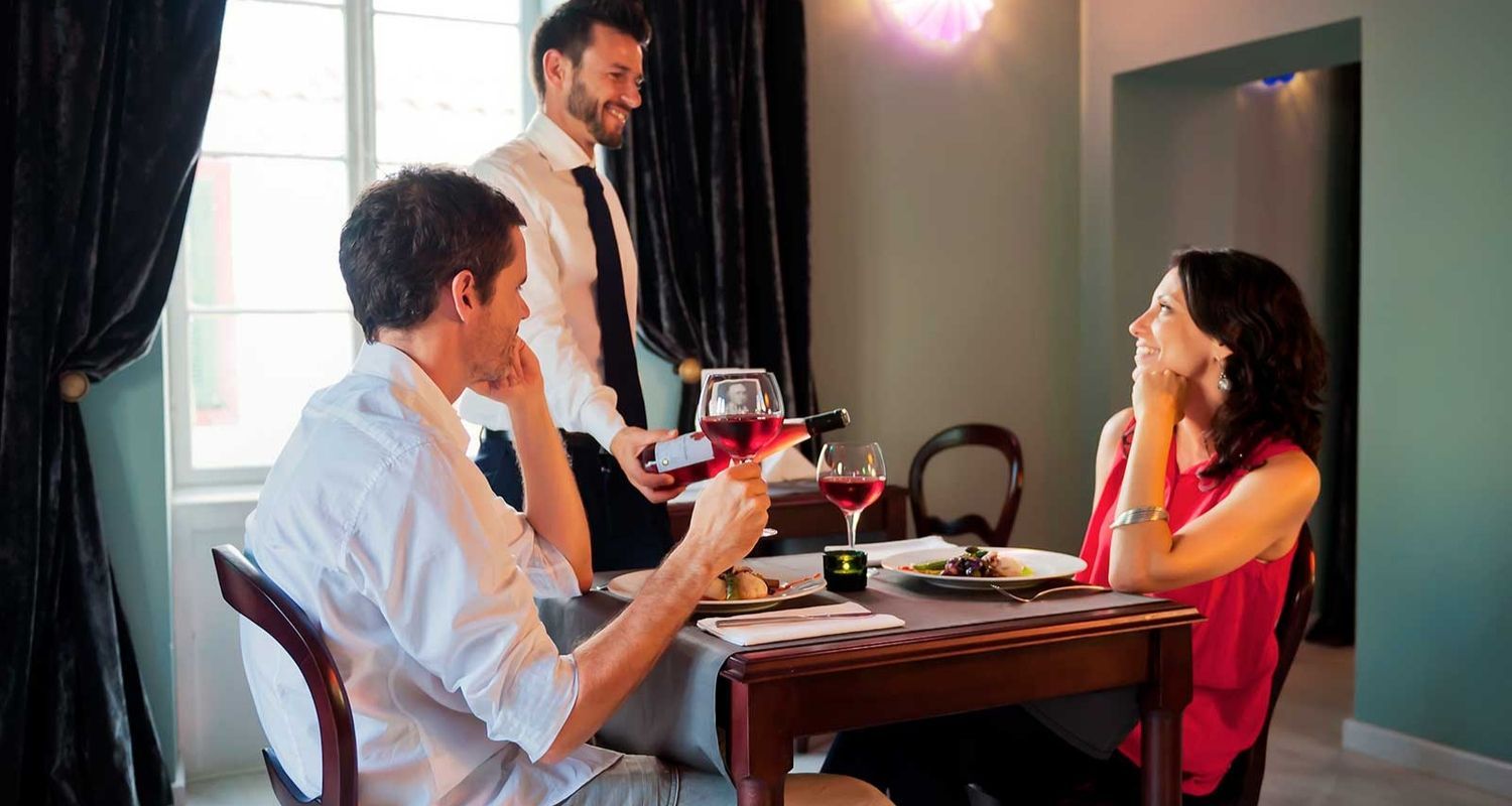 couple being served by a friendly waiter