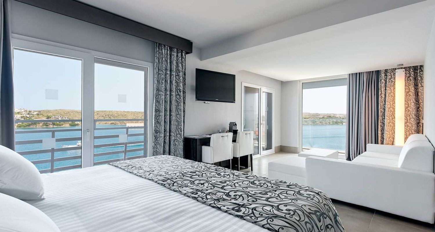 spacious hotel room with sea view and lounge area