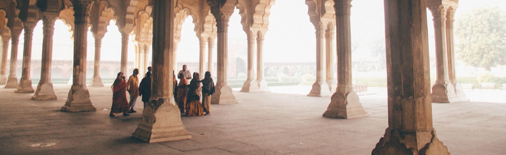 people walking behind pillars