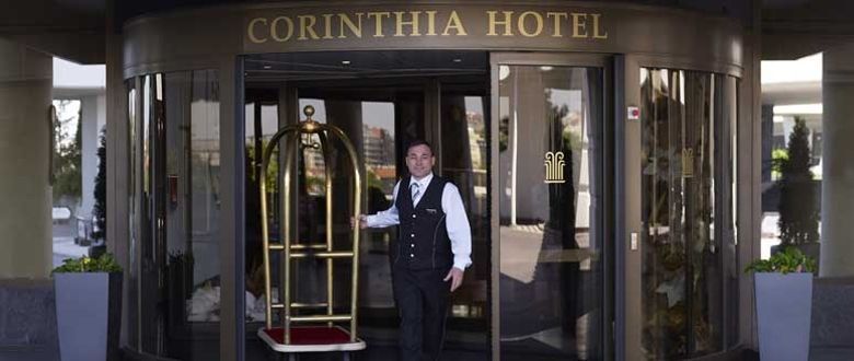 Corinthia Hotel Prague exterior with a friendly staff member bringing out someones bags