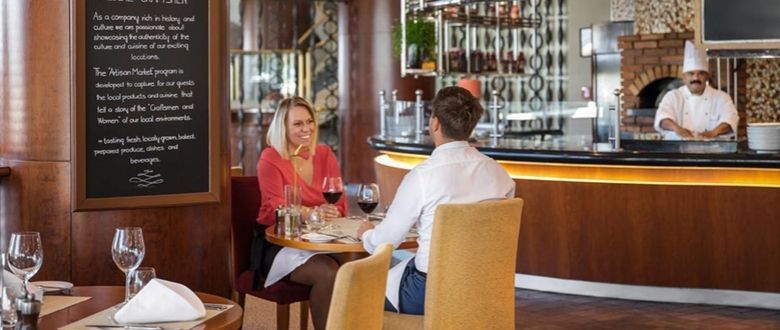 a couple of guests enjoying some wine while a friendly staff member looks on