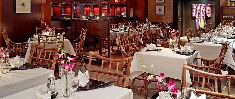 fancy indoor restaurant with flowers surrounding the dining tables