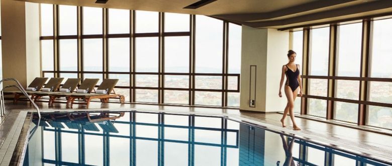 hotel guest in bathing suit walking around the indoor pool