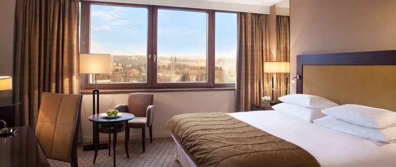 spacious bedroom with lounge chairs and a desk