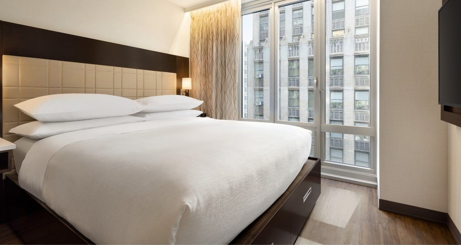 large bedroom with a view of the city