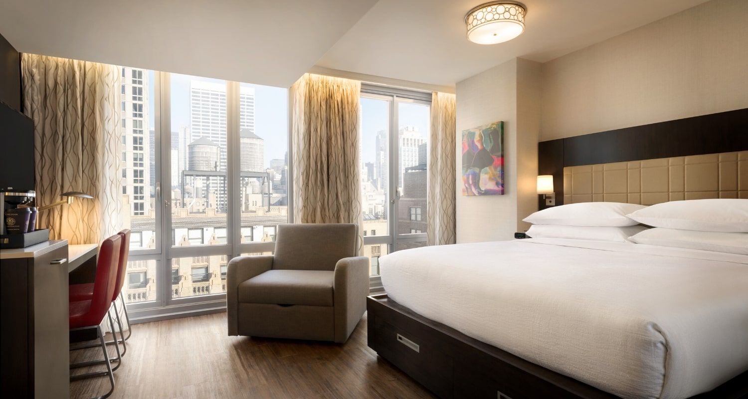 spacious hotel room with a view of the city