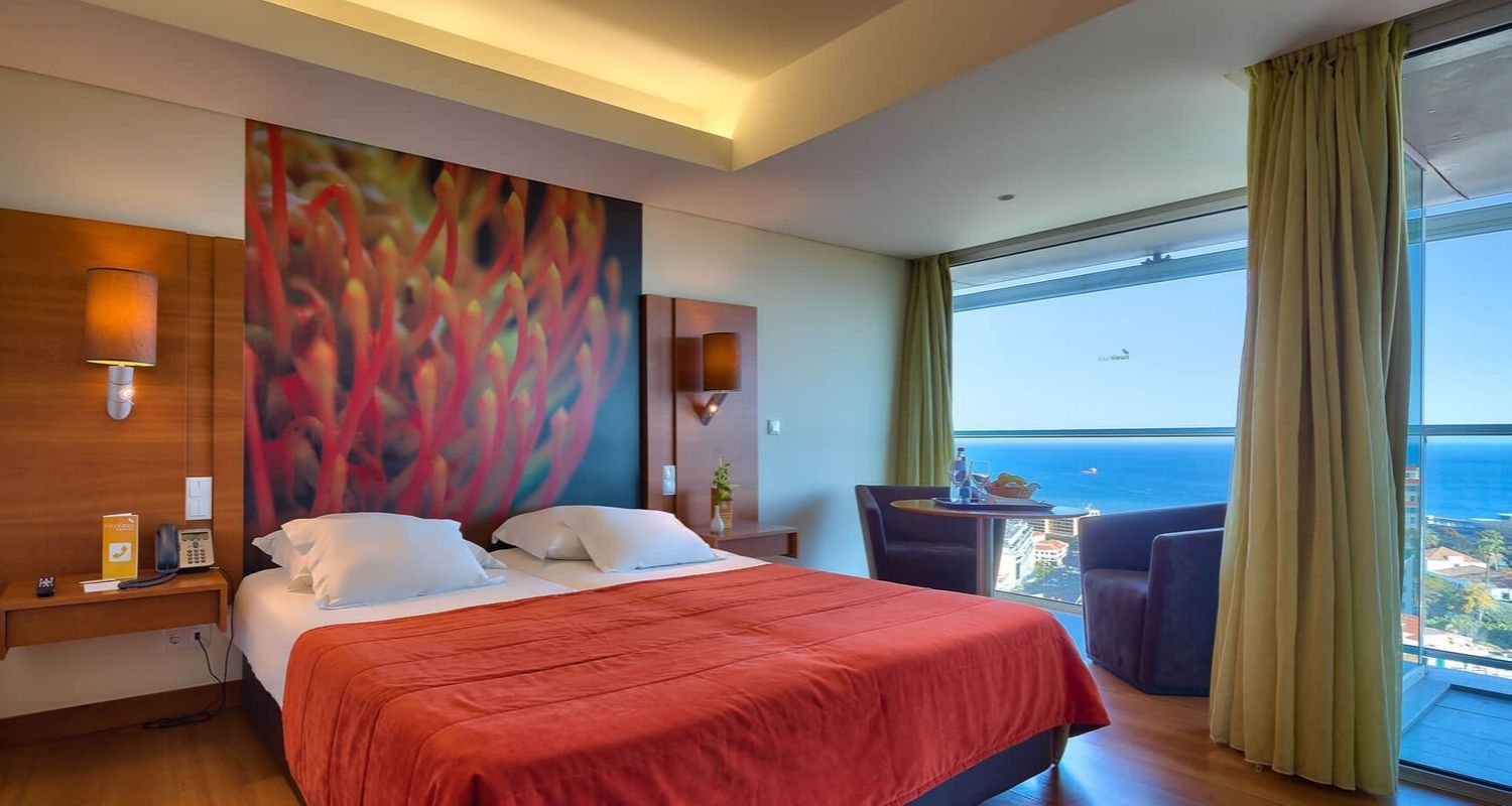 spacious bedroom with a queen sized bed and an ocean view