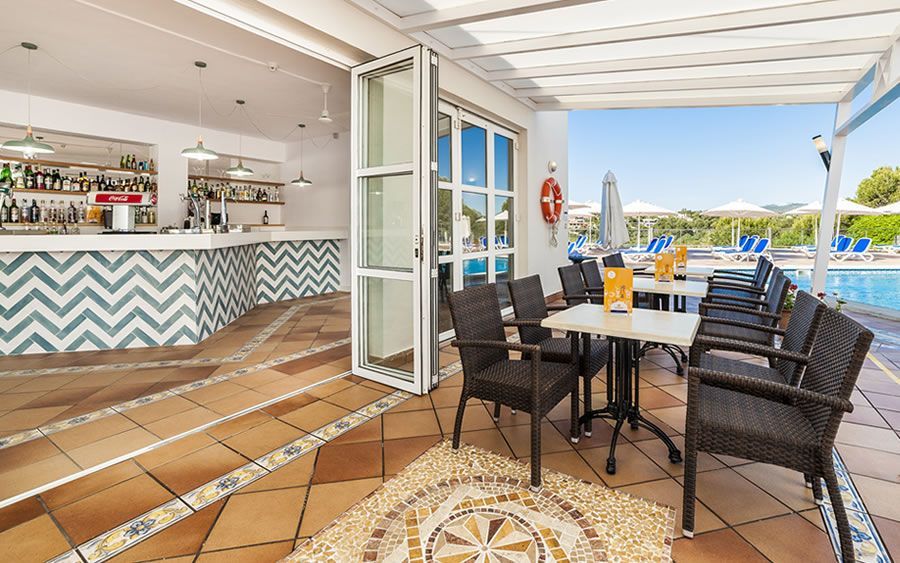 outdoor dining in between the indoor bar and pool