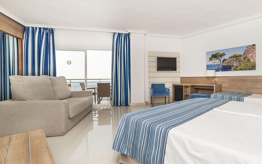 spacious hotel room with a sofa and balcony terrace