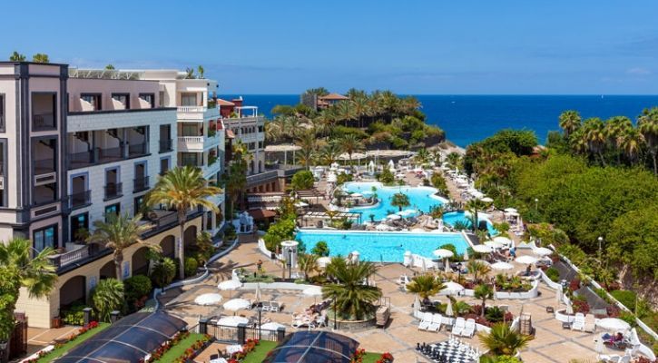 aerial view of the hotel grounds showing the exterior of the main building and outdoor swimming pools