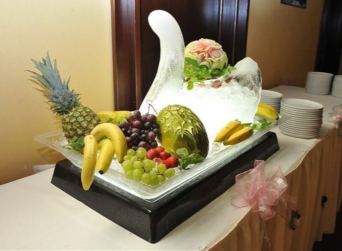 swan ice sculpture surrounded by fruit