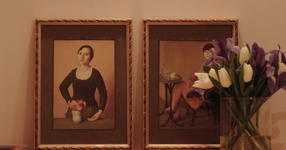 framed paintings on the wall beside colourful flowers