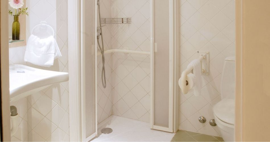 adapted bathroom with a wheel-in shower and grab rails