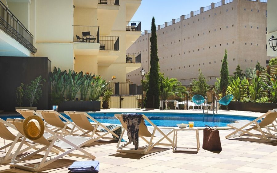 outdoor swimming pool with sunbeds surrounding it