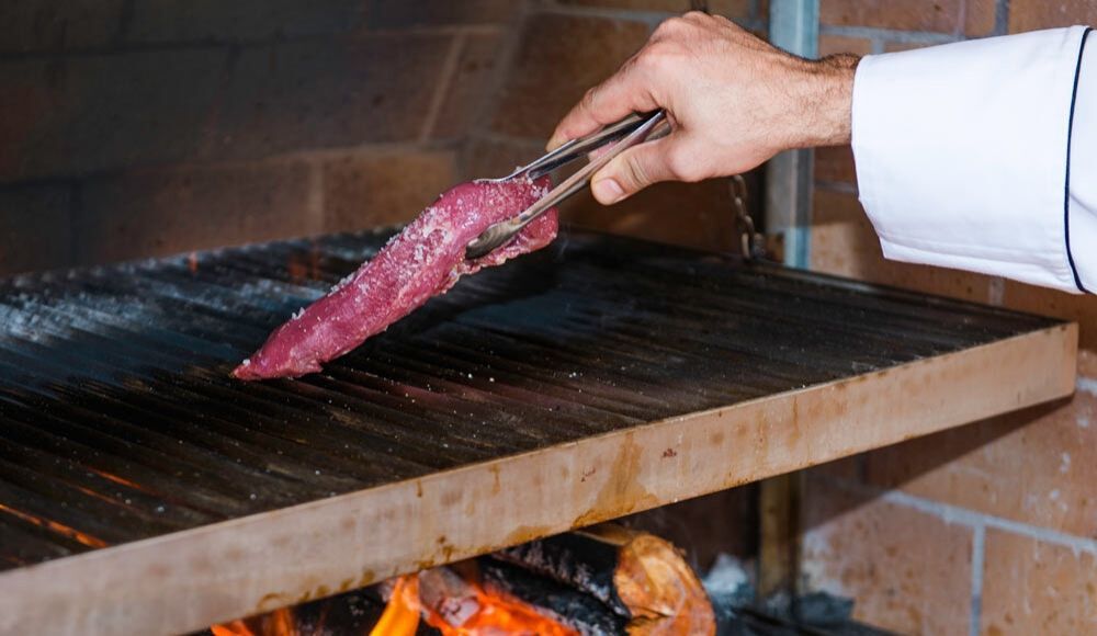 chef placing steak onto the fryer