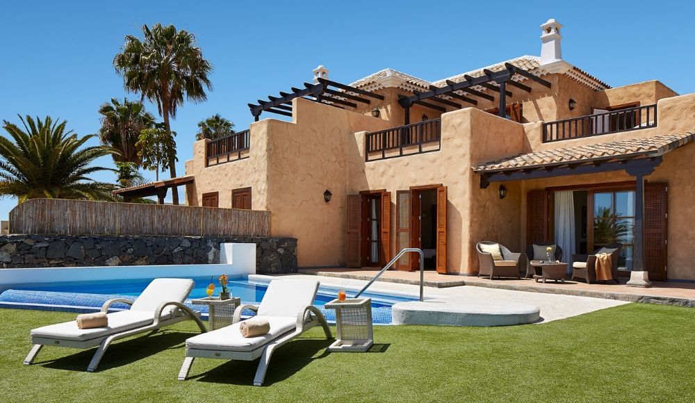 villa exterior with sunbeds and an outdoor pool