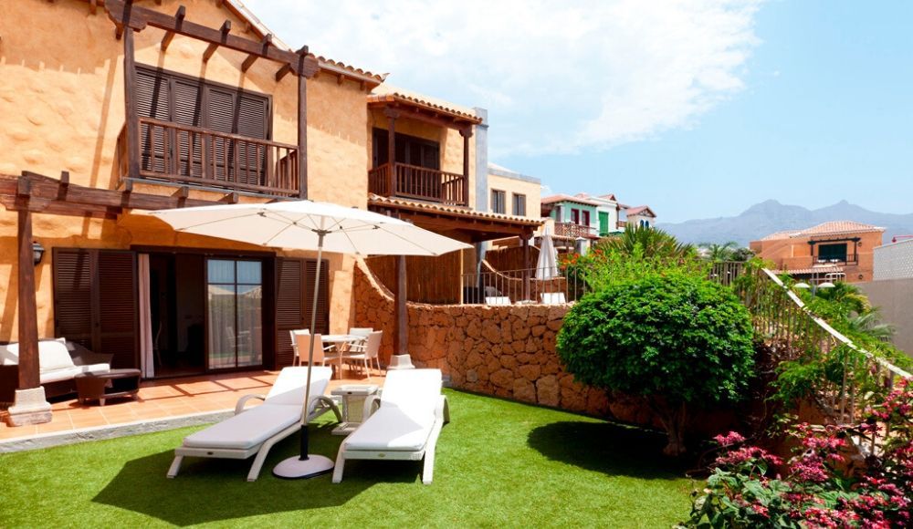 villa exterior with sunbeds and an umbrella