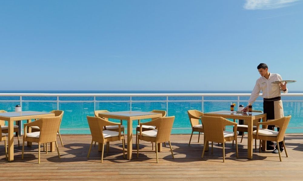 friendly staff member cleaning up tables