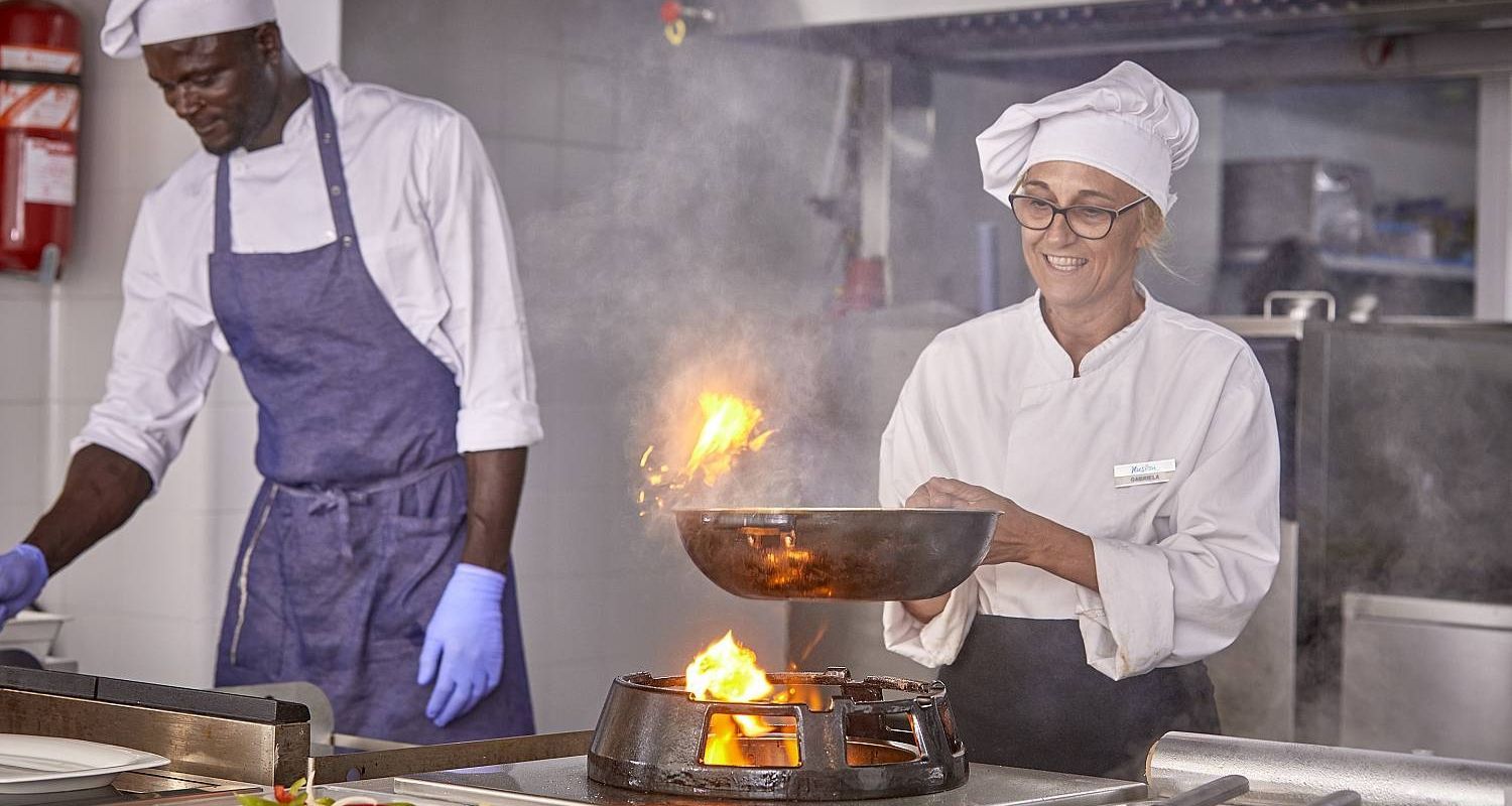 professional chef cooking over an open flame