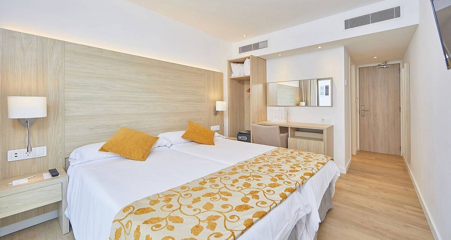 spacious bedroom with a wardrobe beside the bed