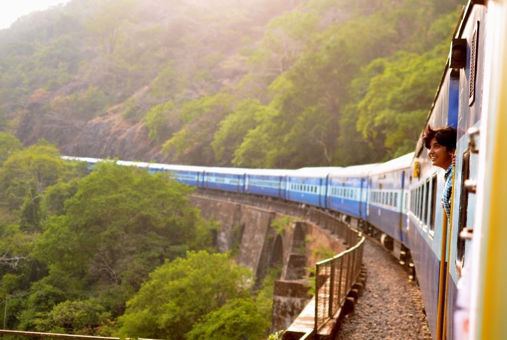 Passenger sticking their head out of a train to take in the view