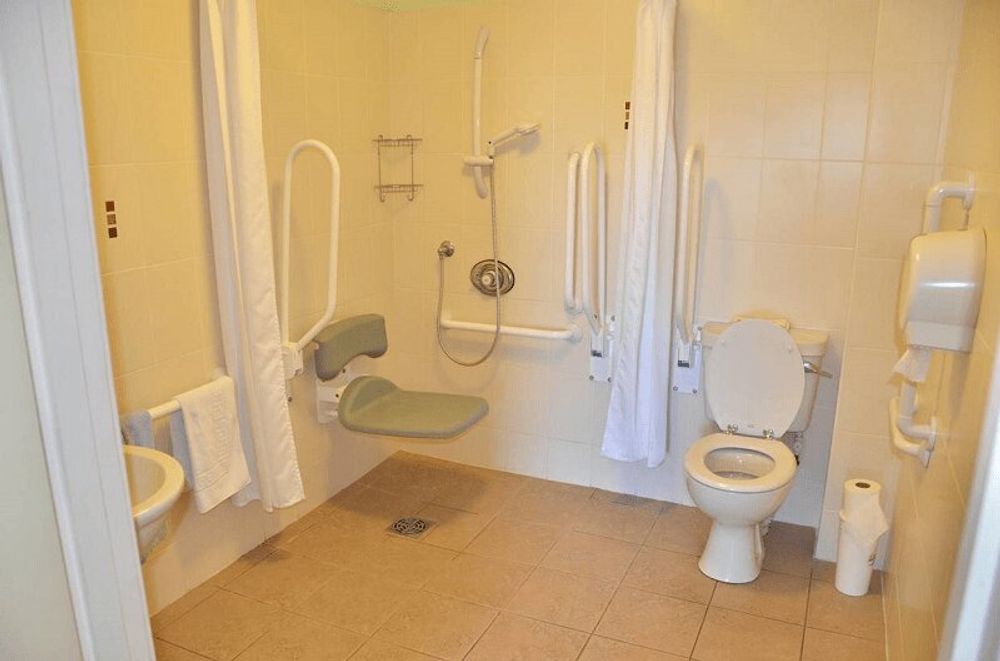 Example of a wall-mounted shower chair at the Maison des Landes in Jersey, Channel Islands