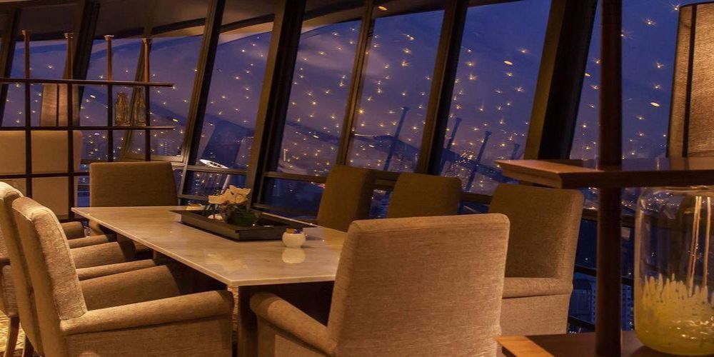 cosy dining area with a nighttime view of the city