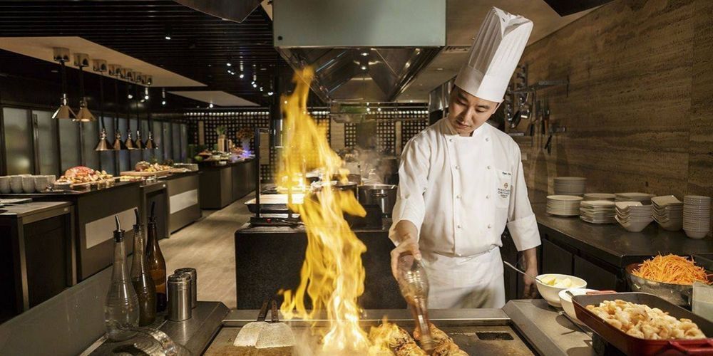 trained chef cooking over an open flame