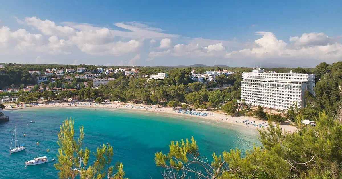 hotel exterior from a local hilltop showing the beautiful beach and colourful water