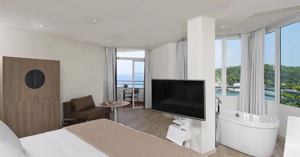 spacious hotel room with a balcony and flat screen tv