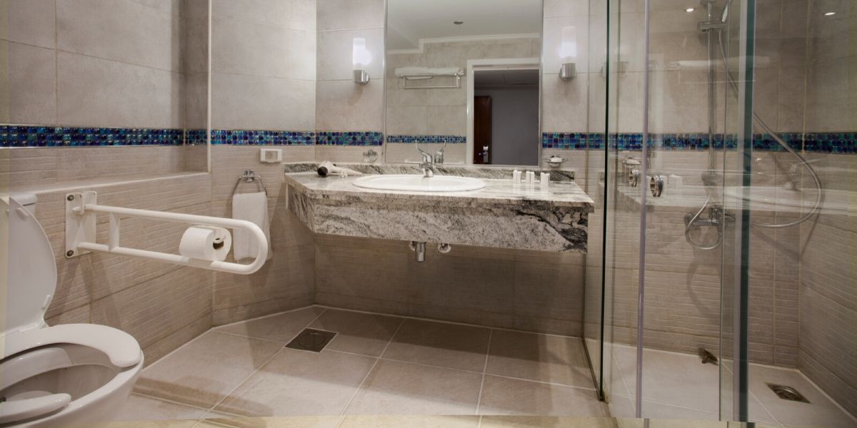 adapted bathroom with grab rails and a wheel-in shower