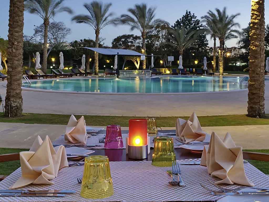 outdoor dining with a view of the swimming pool