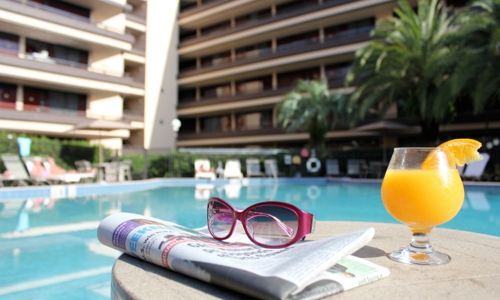 hotel swimming pool with sunglasses and a glass of orange juice