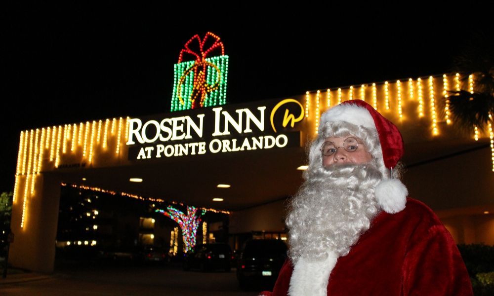 Santa Claus standing outside of the hotel with Christmas decorations