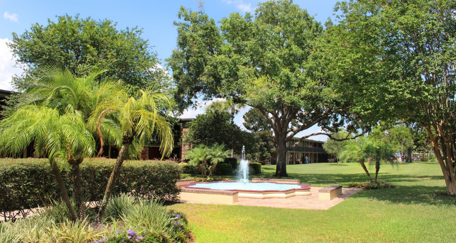 an open garden on the hotel grounds with a water fountain