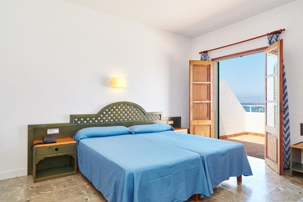 twin beds pushed together with an open door leading to the balcony