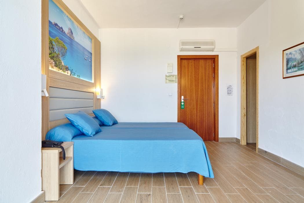 spacious bedroom with a double bed that has blue sheets