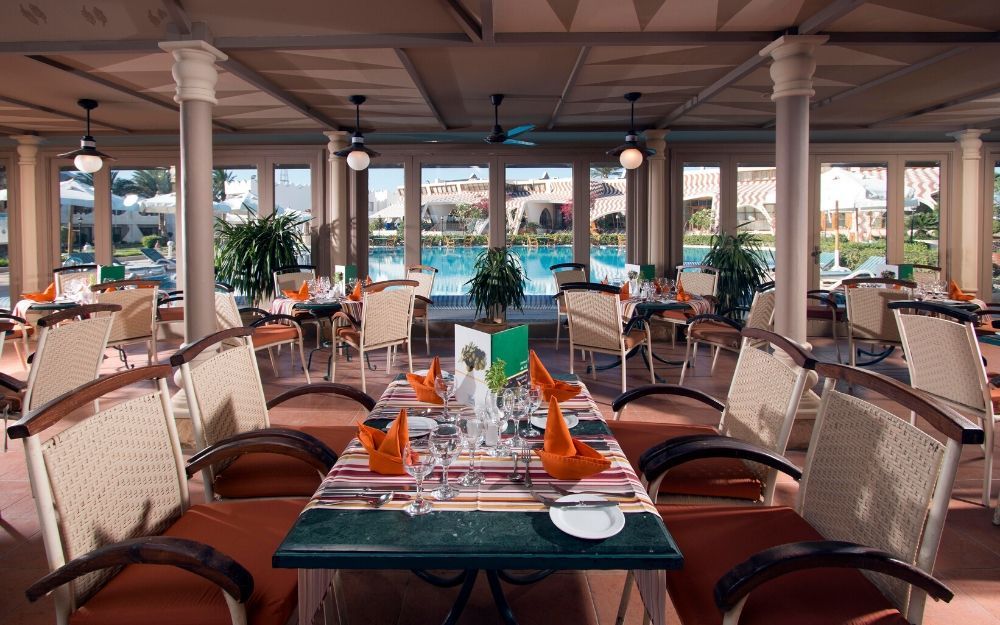 indoor restaurant and dining room with a view of the outdoor swimming pool