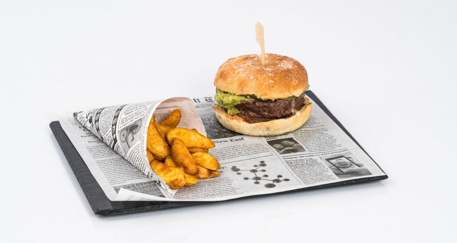 burger and fries sitting on newspaper wrapping