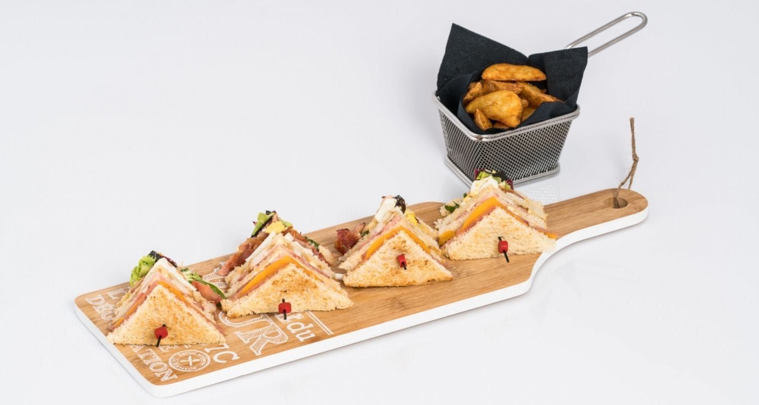 cheese toasties and wedges sitting on a wooden plank