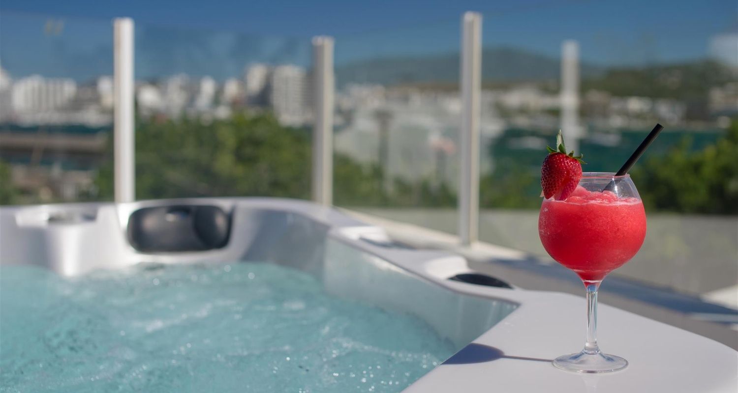 red cocktail sitting on the side of the hot tub
